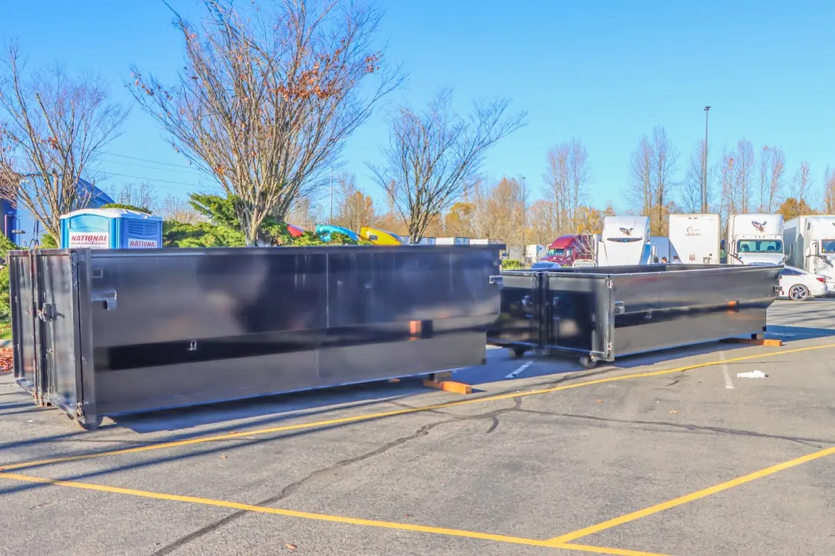 Professional dumpster rental service with roll-off container on residential driveway in Hollis